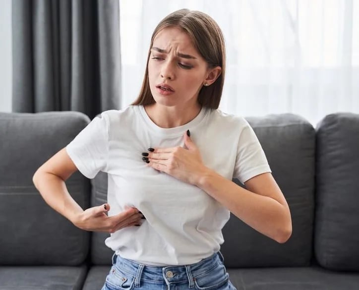 Woman noticing firmness and discomfort from an aging breast implant