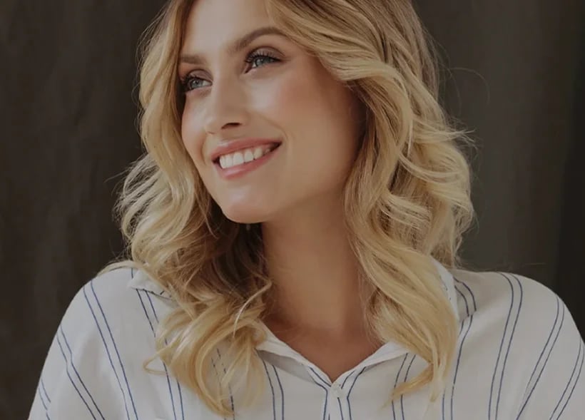 Smiling woman, representing the quicker first-day recovery awake breast augmentation allows