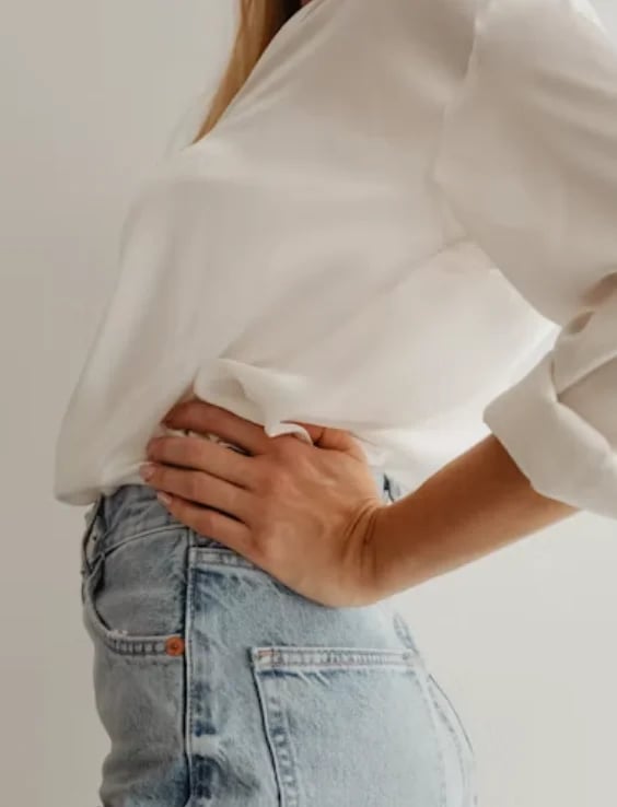 Woman in jeans with a hand on her waist, the midsection Lipo 360 contours